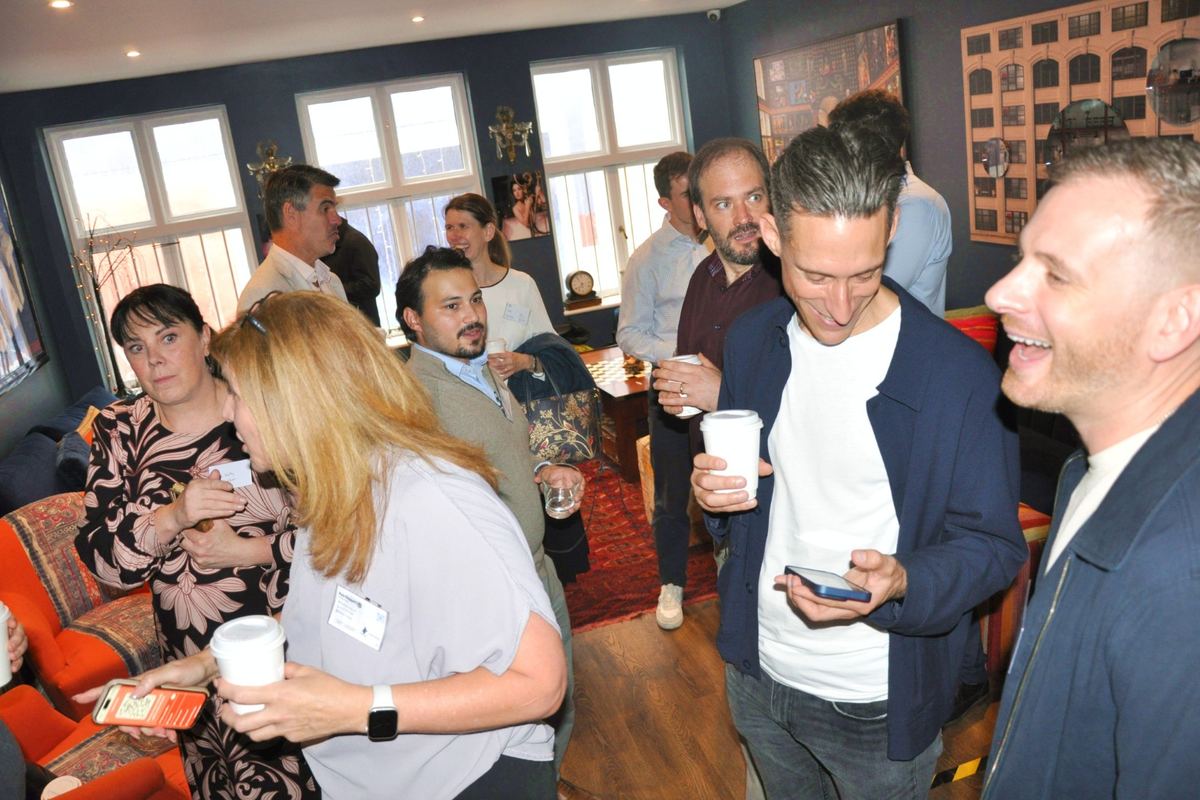 Guests talking and laughing over coffee at a networking event